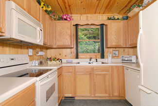 The kitchen is u shaped with the stove, microwave on the left side. then the sink striaght ahead with a window facing the woods, and the refidgerator and dishwasher on the right side of the u.